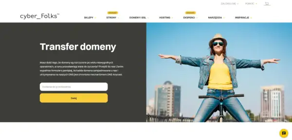 Kobieta na rowerze z rozłożonymi rękami, na tle miasta i formularza do przeniesienia domeny.